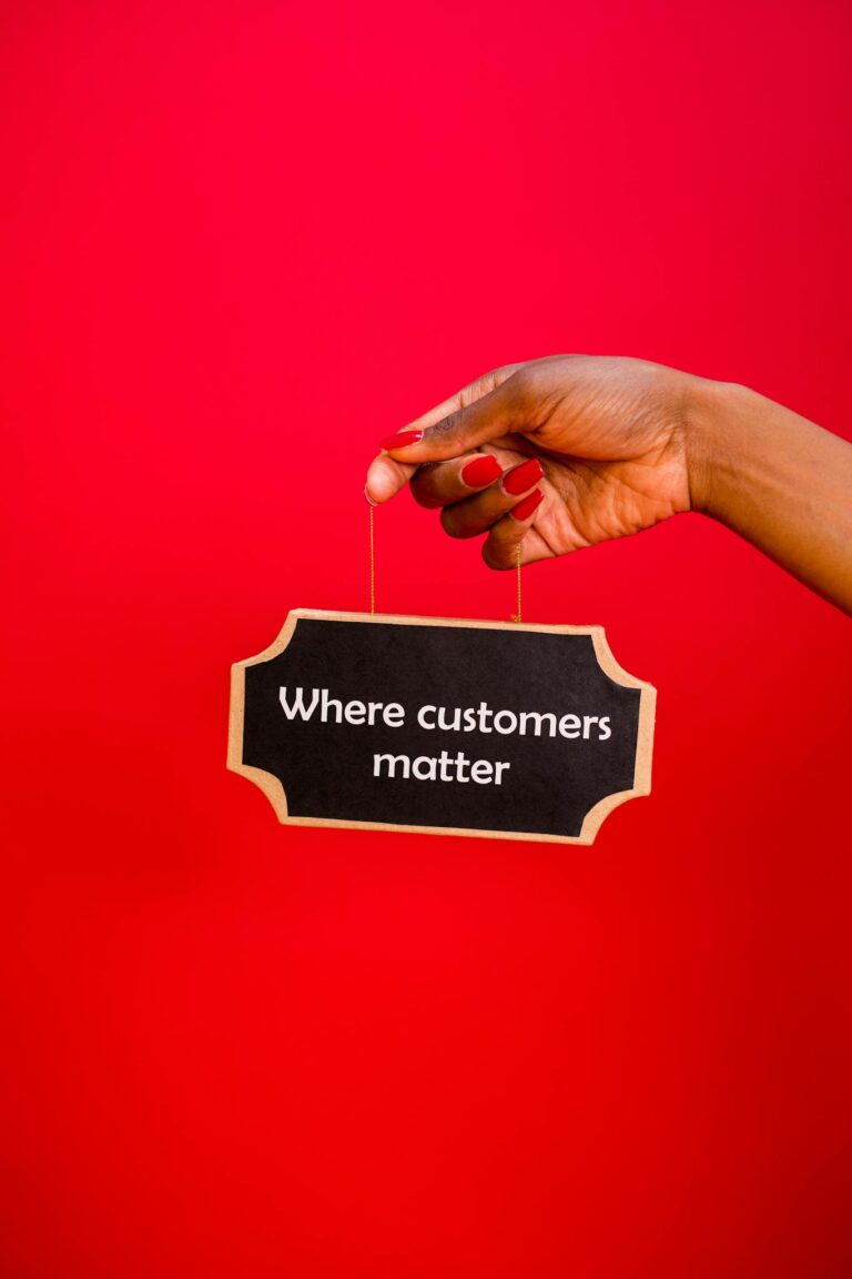 A hand holding a sign with the text 'Where customers matter' against a red background.